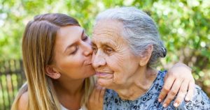 Granddaughter kissing her grandmother's cheek