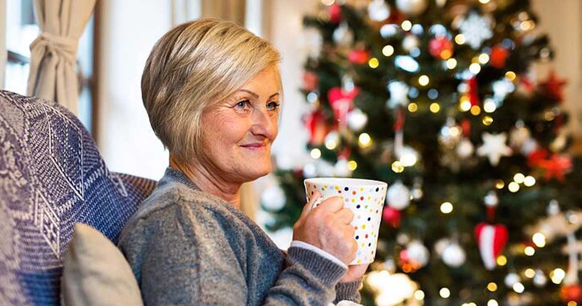 Senior woman in front of a Christmas tree