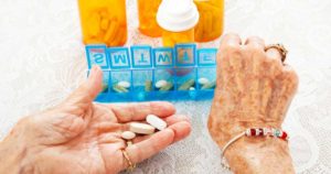 elderly hands sorting pills