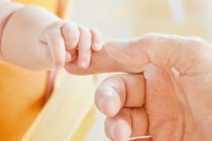 Baby holding a a man's index finger