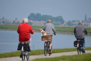 three seniors riding their bikes along the lakeshore