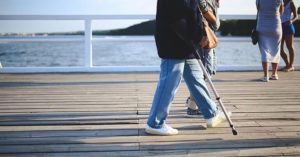 Senior with cane walking on boardwalk