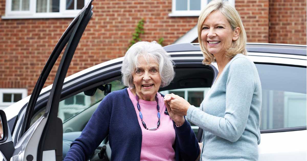 female neigbour giving senior woman a lift in car