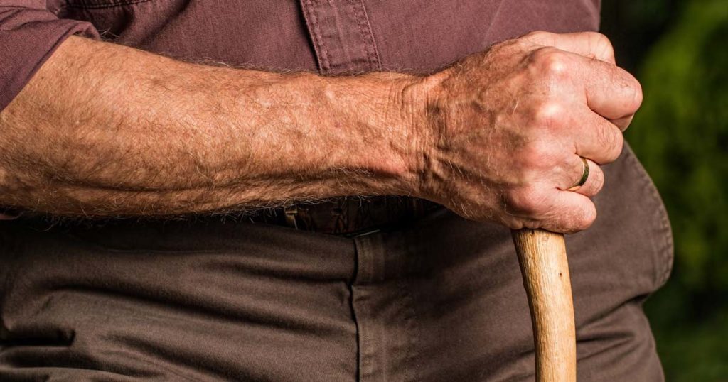 close up a senior man olding a cane