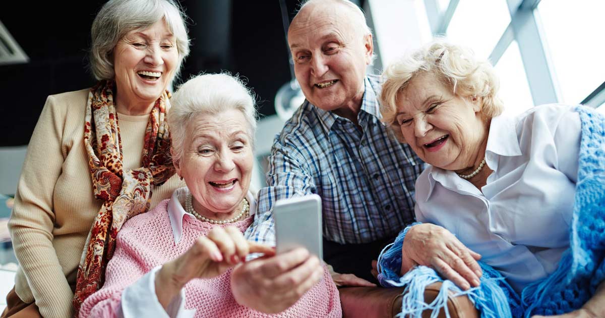 a group of seniors facetiming on a smartphone