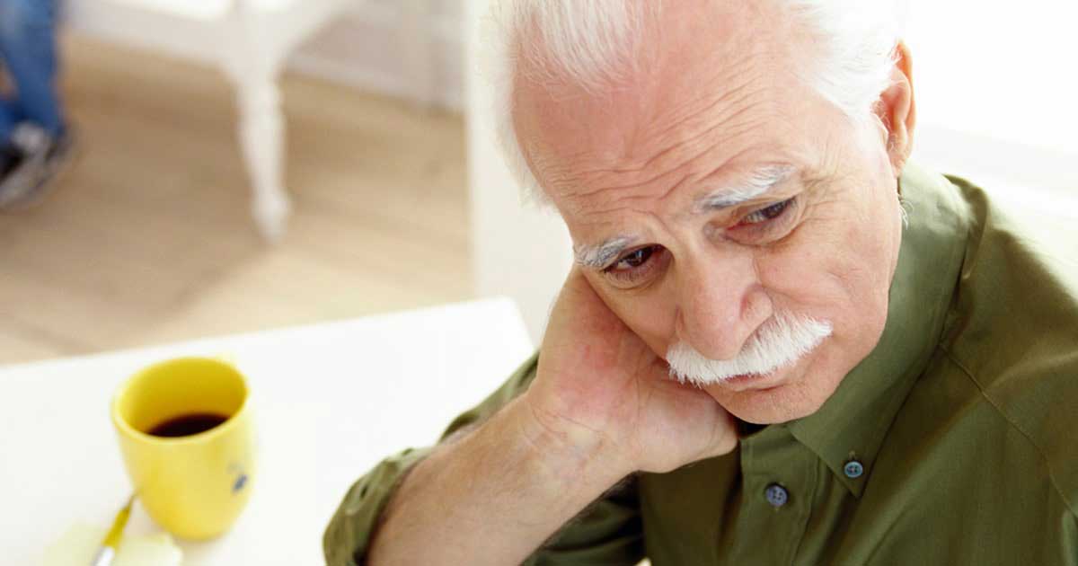 Senior man sitting anxiously at a table