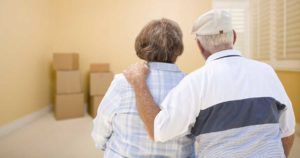 senior couple in room looking at moving boxes