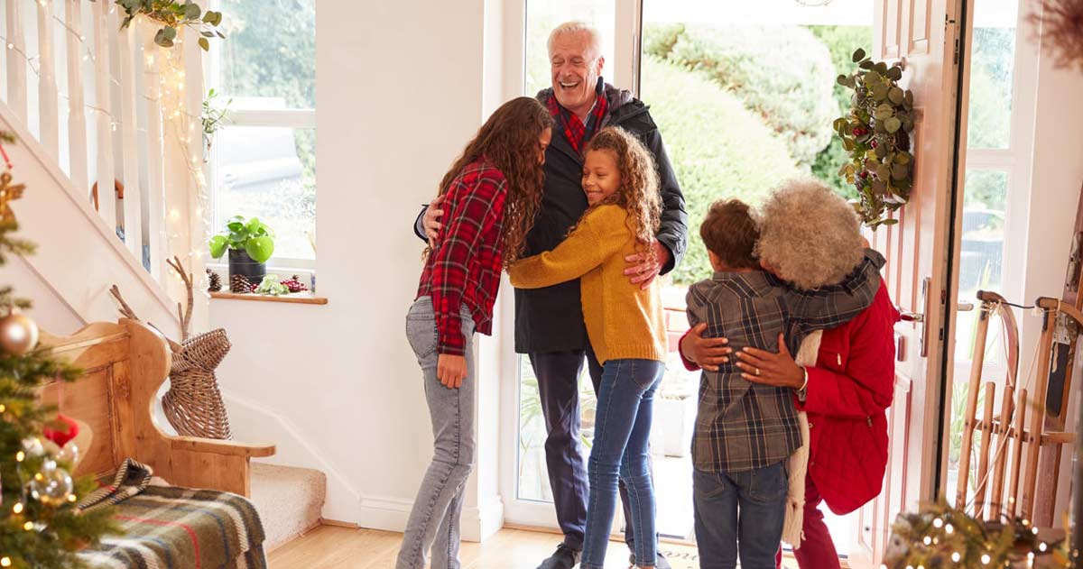 Grandparents being greeted by their grandkids at the door at holiday time