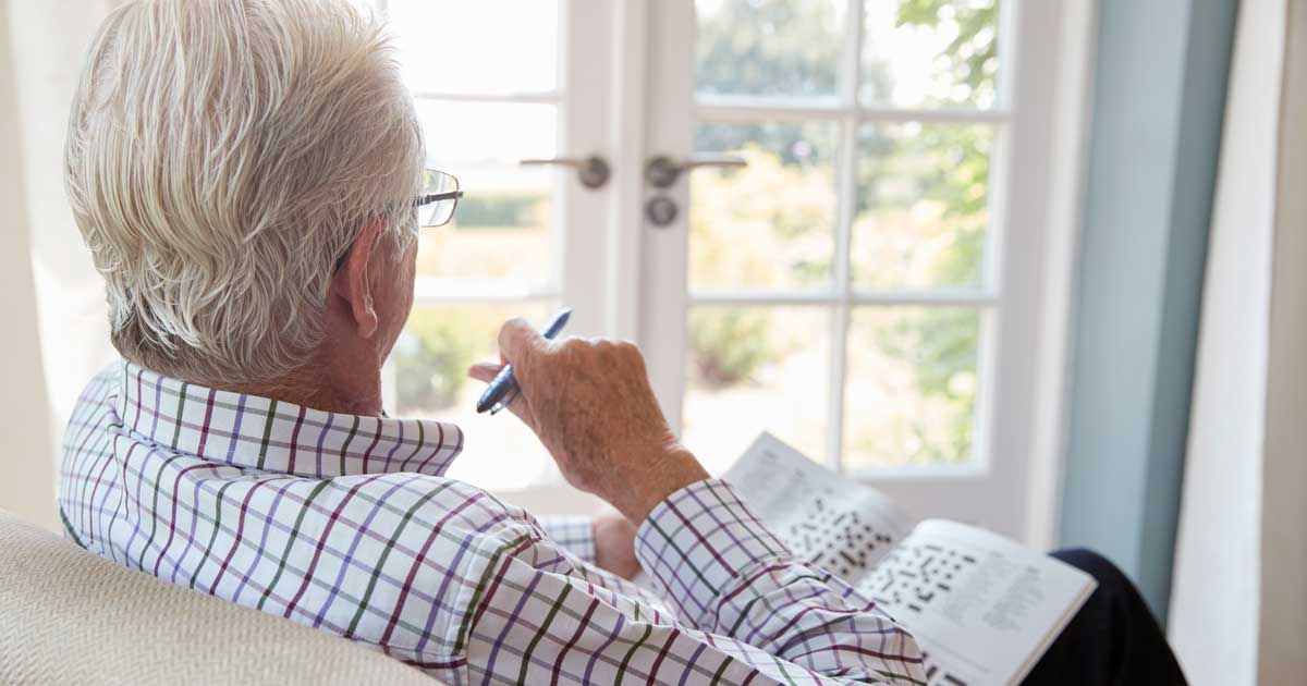 senior man doing a crossword puzzle