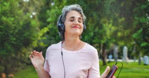 Senior woman wearing headphones and enjoying music