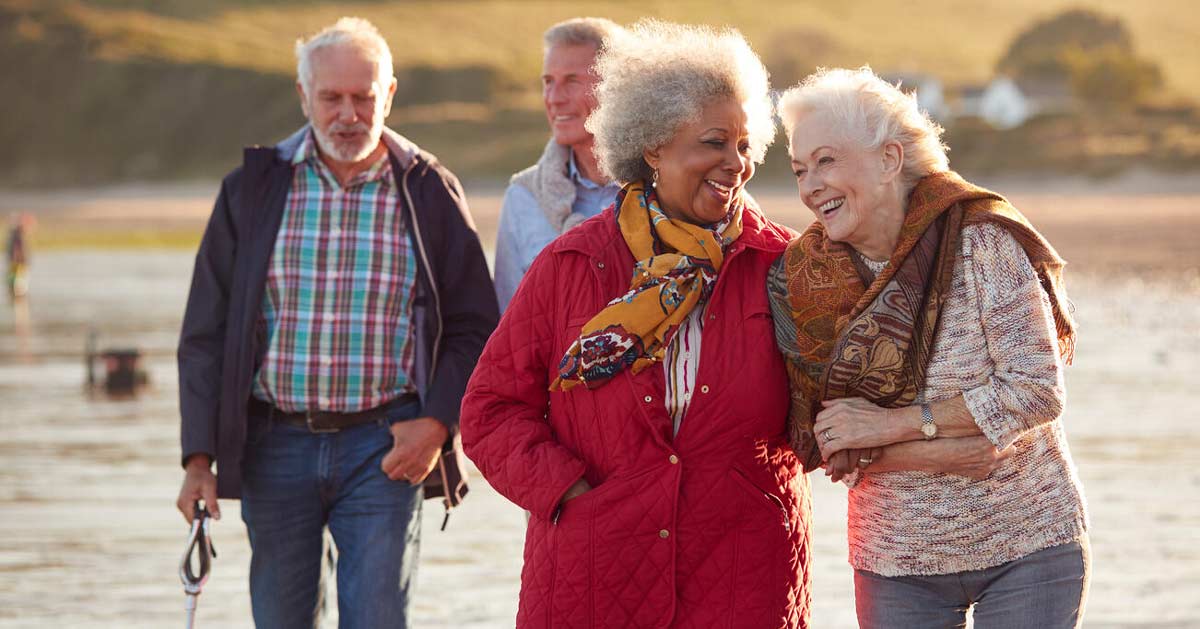 multiracial senior couples socializing on the beach
