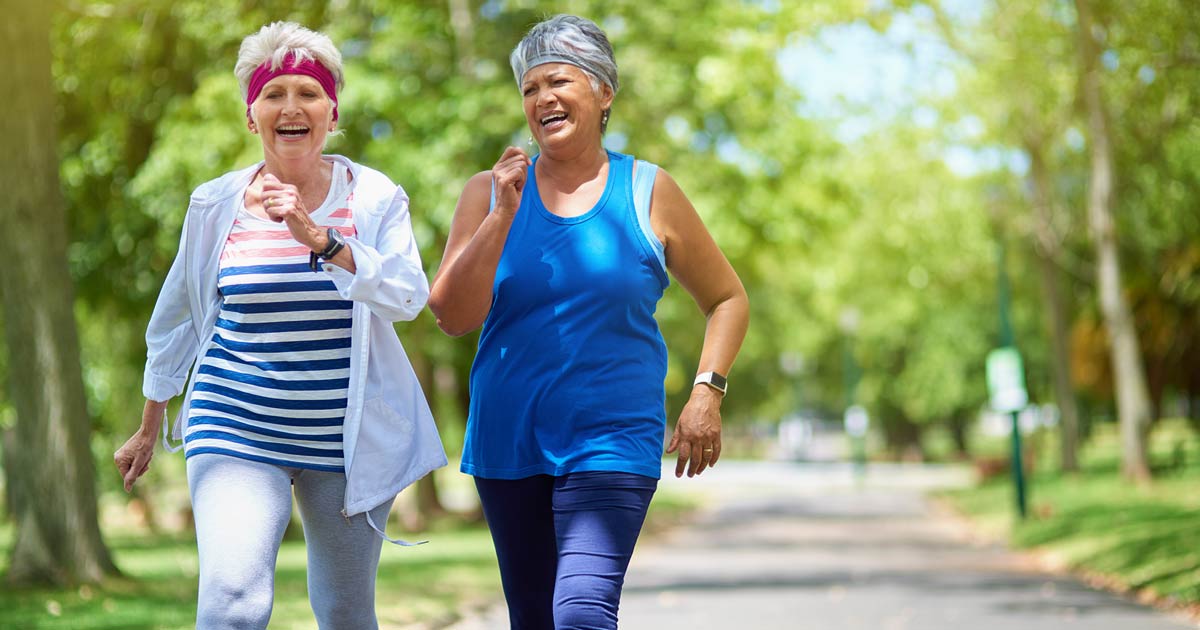 Two senior women out on a walk in the park