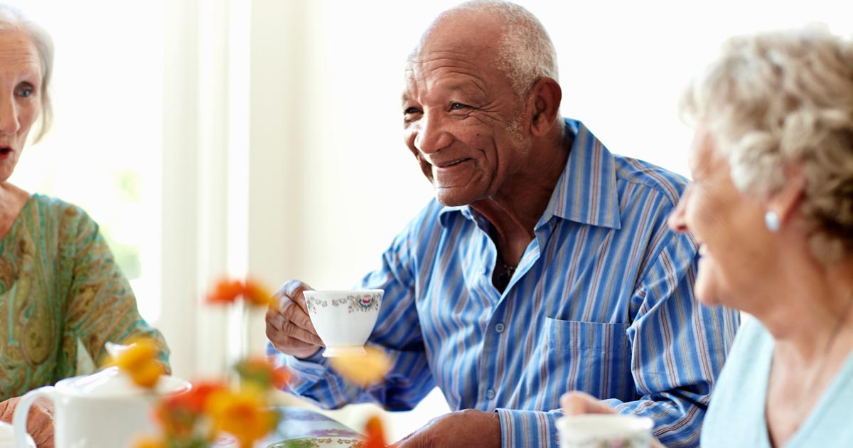 Senior man having tea with his senior friends
