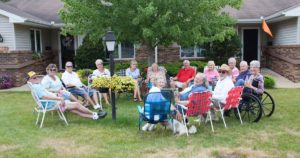 Seniors socializing on lawn outside John Ganton's residence